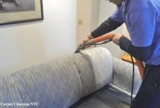 Man steam cleaning upholstery